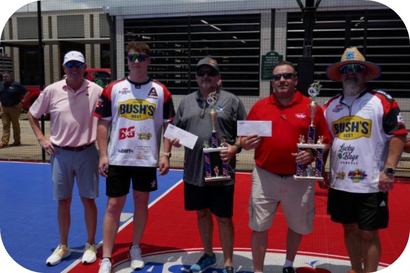 A group of men holding trophies.