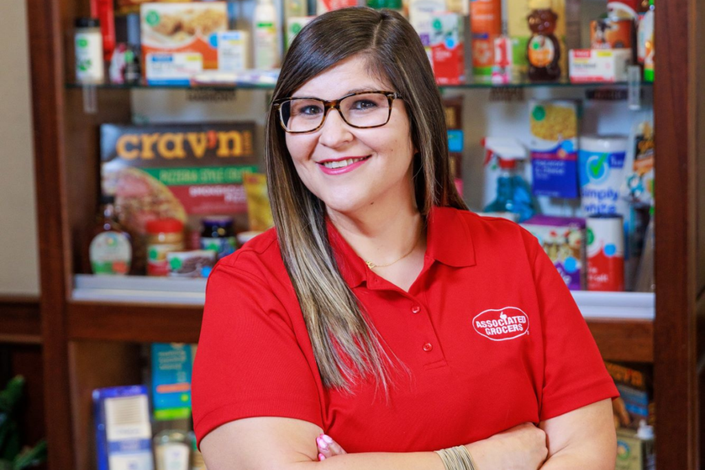 Woman standing with Associated Grocers' Family of Brands.