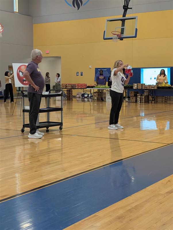 Robin and Jimmy Burrow lead a Healthy Minds, Healthy Bodies presentation in a school gymnasium.