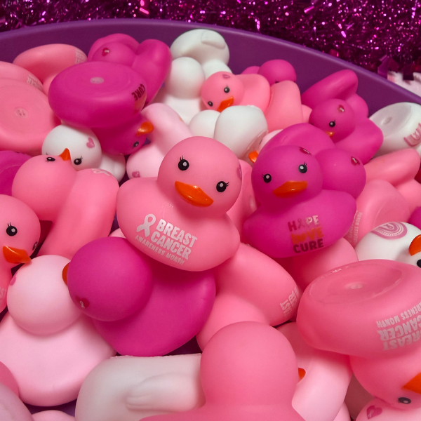 Pink and white rubber ducks with breast cancer awareness messages displayed as giveaway items during the AG Goes Pink Breast Cancer Awareness event.